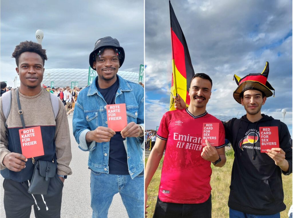 Hier ist Bild 4 zu sehen. Es zeigt Fußballfans mit den roten Karten der Kampagne vor der Allianzarena in München.