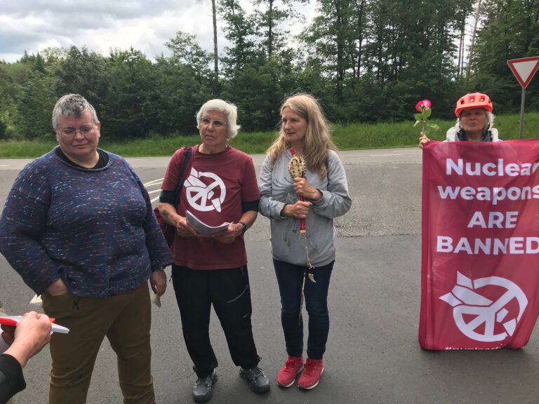 Hier ist das Titelbild zu sehen. Es zeigt die Mahnwache am 30.5.2024 vor der Kommandantur der Fliegerkaserne in Cochem-Brauheck, 10 Kilometer von Büchel entfernt, mit Susan van der Hijden und Susan Crane (1. und 2. v. l.)