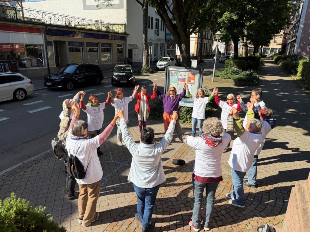 : Die Teilnehmer*innen tanzen zu dem kolumbianischen Friedenslied „Para la guerra nada“ (Für den Krieg nichts)